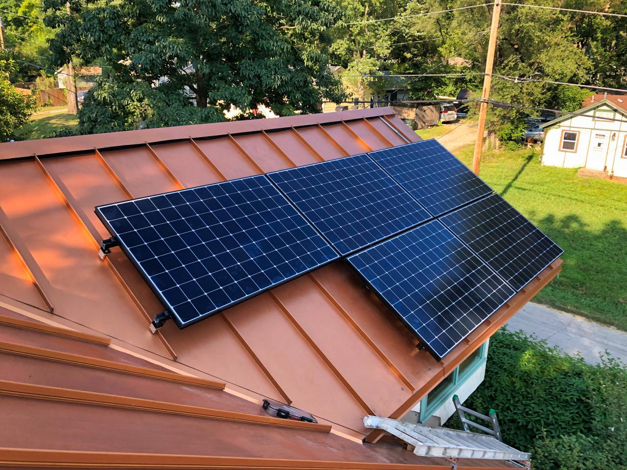 Solar panels installed on a metal roof with ladder access